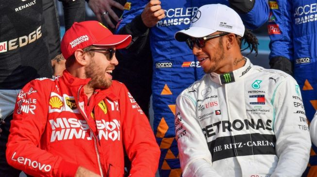 Pebalap Ferrari Sebastian Vettel (kiri) sedang berbincang dengan rivalnya dari Mercedes, Lewis Hamilton. [AFP/Giuseppe Cacace]
